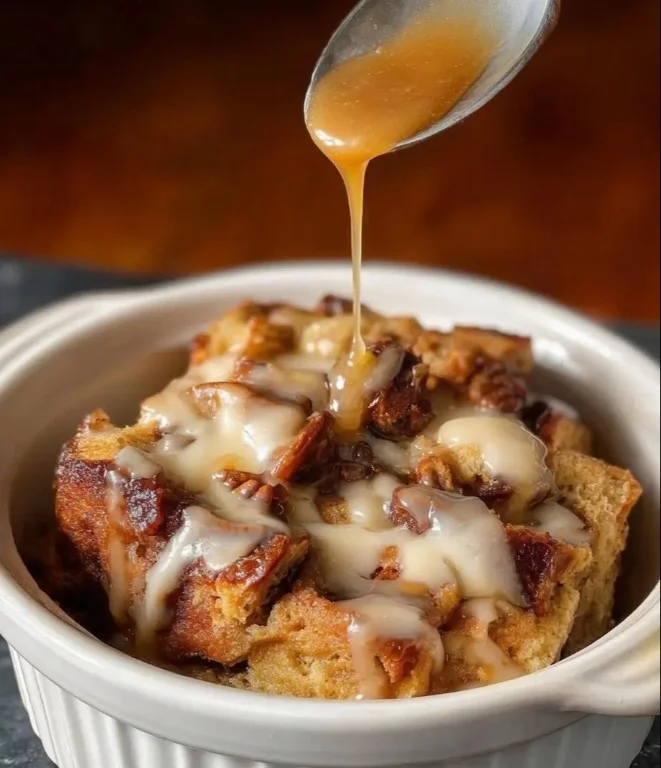 Delicious Crock Pot bread pudding served in a bowl topped with caramel sauce.