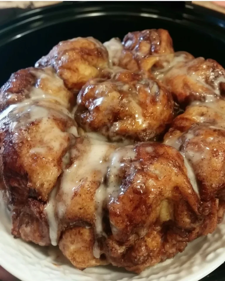 Crockpot Cinnamon Roll Monkey Bread served on a rustic wooden table