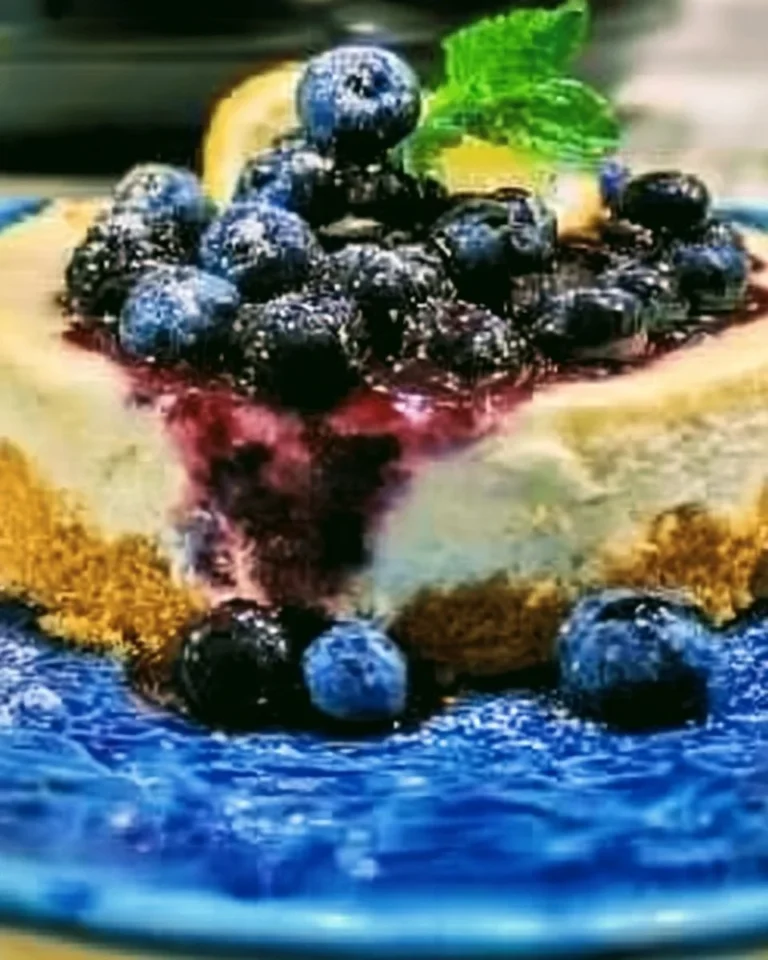 Crock Pot Lemon Blueberry Cheesecake topped with fresh blueberries and lemon zest.