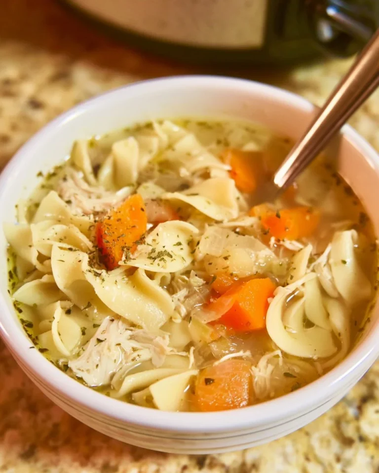Bowl of hearty Crockpot Chicken Noodle Soup with fresh herbs and noodles