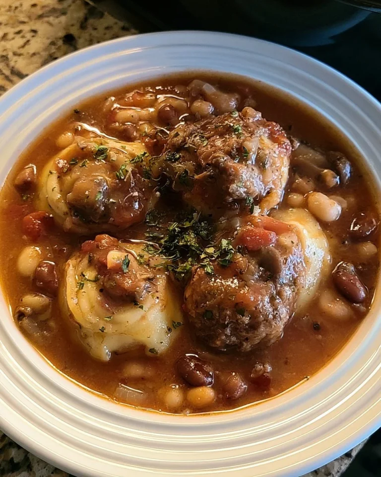 Bowl of Crockpot Pasta e Fagioli soup, Olive Garden style, garnished with herbs.