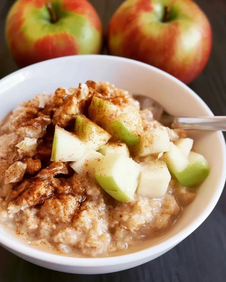 Delicious bowl of Overnight Crockpot Oatmeal with Apples and Cinnamon topped with fresh apples.