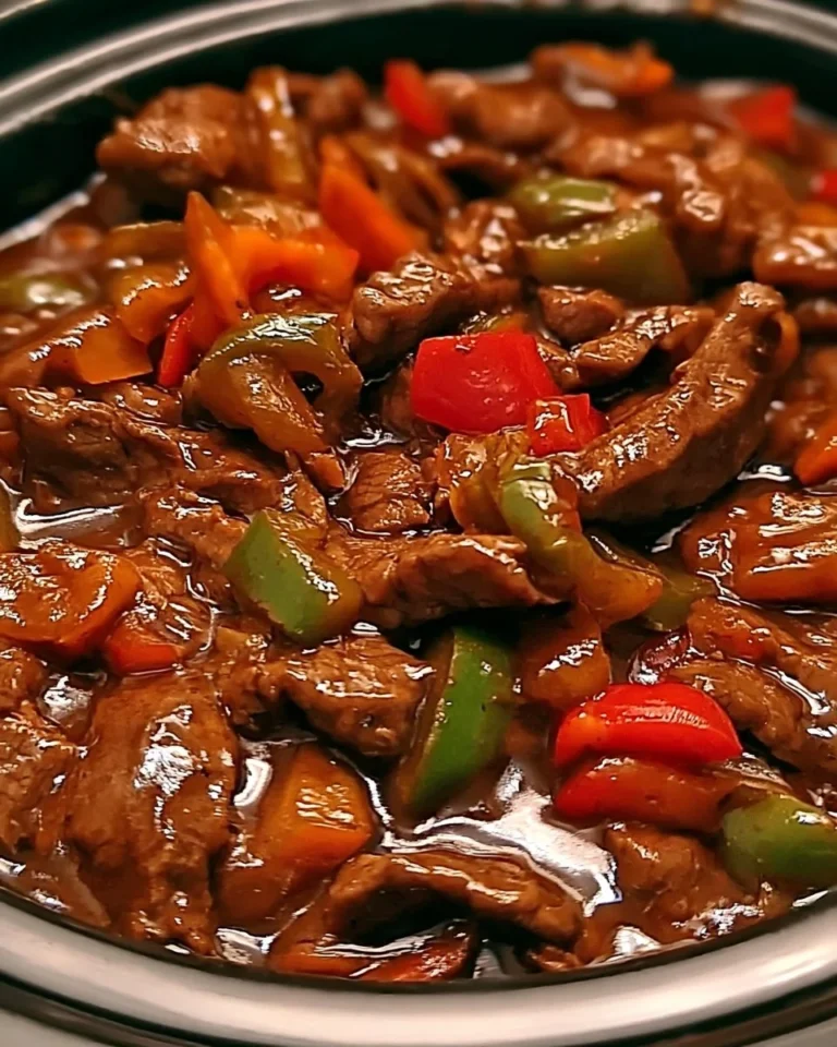 Delicious Crockpot pepper steak served with vegetables and rice.